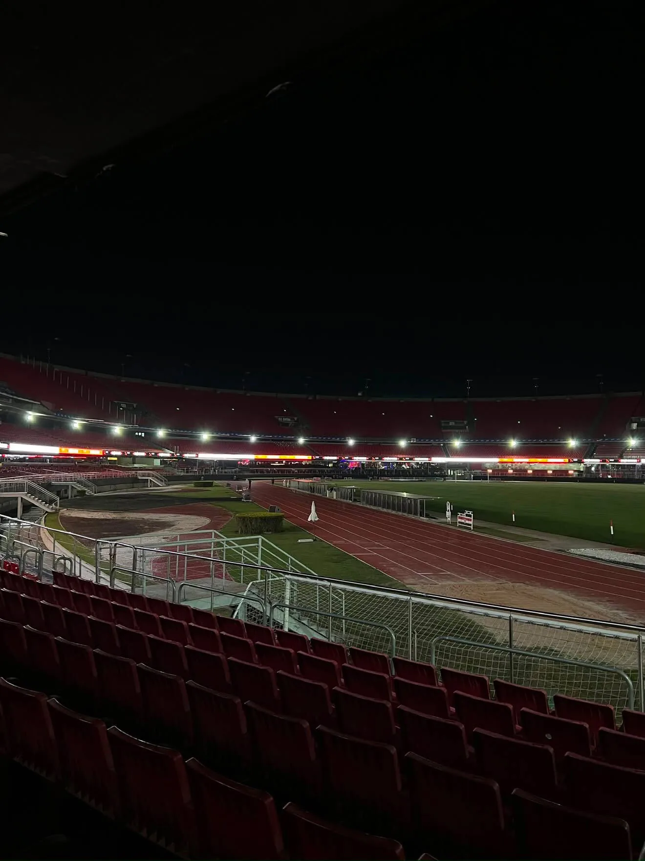 The Morumbis at night from the lower stands, the ring lit along the far side of the bowl