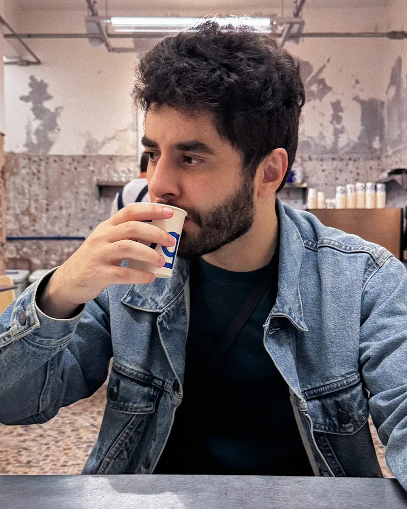 Maikon Miranda at a café table, drinking coffee and talking